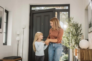 Mutter mit Tochter im Eingang des Hauses.